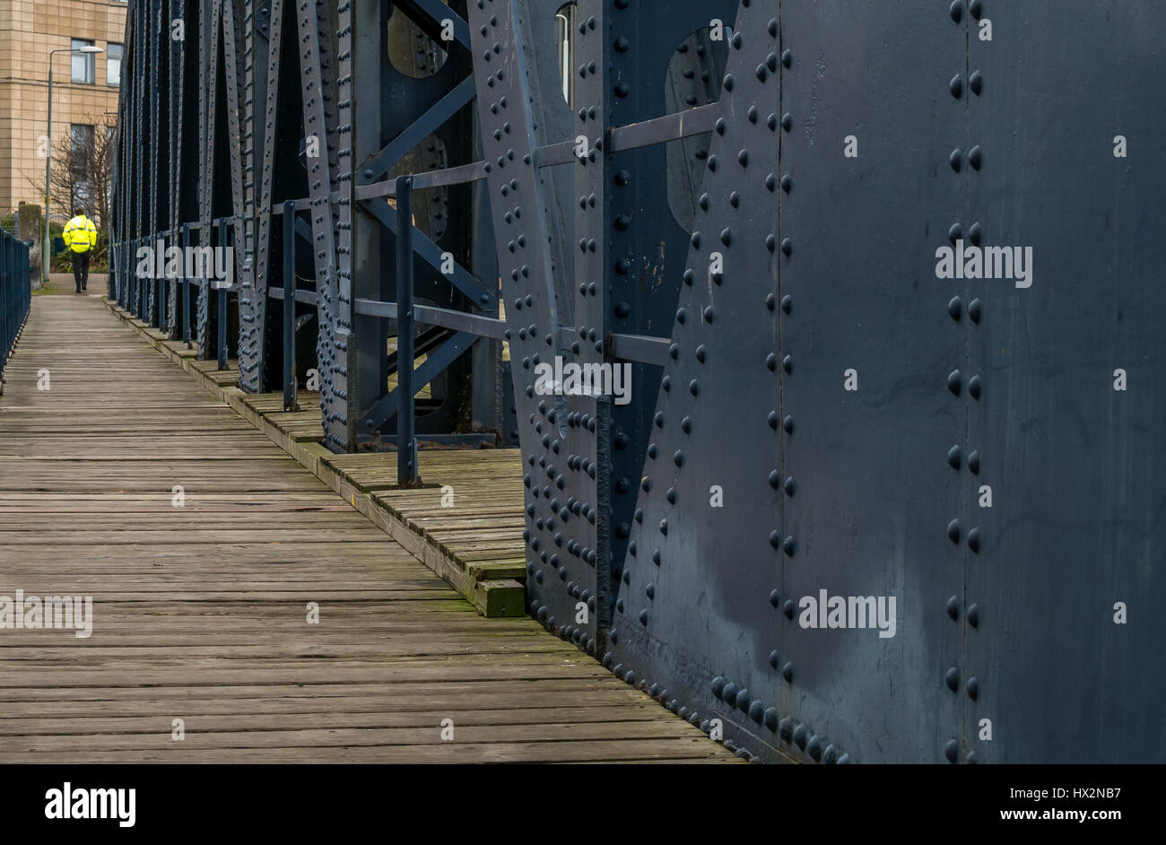 Schmiedeeisen Struktur der alten Victoria Swing Bridge, Leith, Edinburgh, Schottland, Großbritannien, mit der man zu Fuß tragen gelbe Jacke Stockfoto