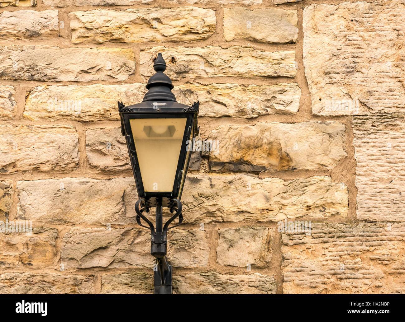 Nahaufnahme der altmodischen verzierten viktorianischen Straßenleuchte an der Sandsteinwand, Edinburgh, Schottland, Großbritannien Stockfoto