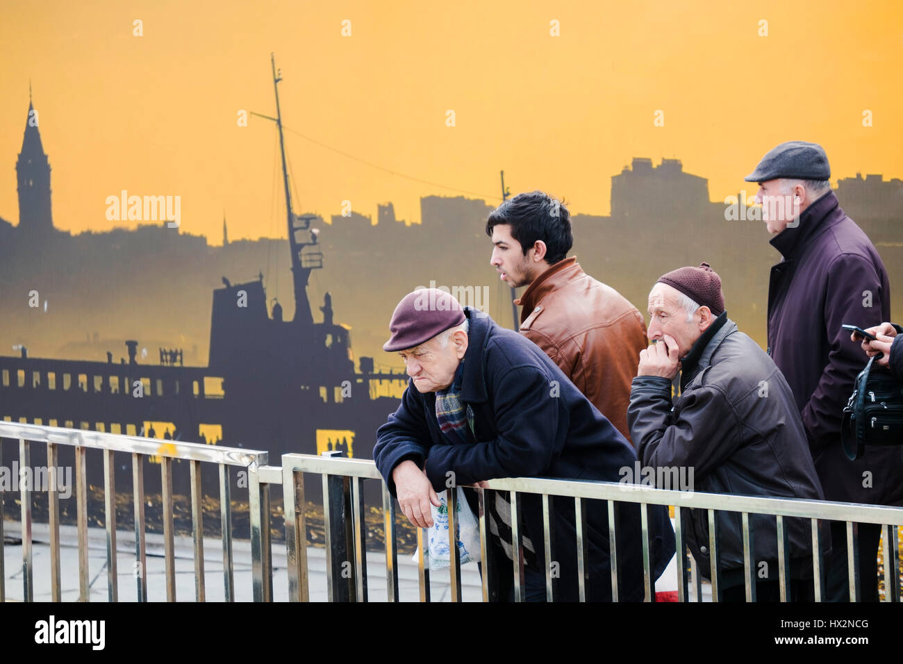 Istanbul, Türkei - 19 Februar 2017: Alte und Junge türkische Männer wartet auf Schiff vor ein interessantes Plakat an der Istanbul, Türkei Stockfoto