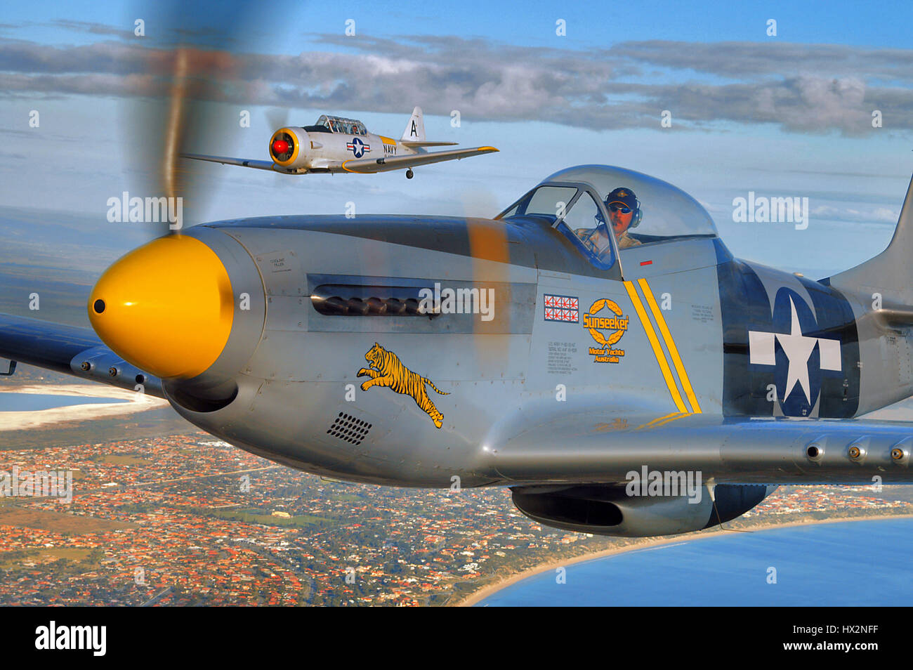 Zwei nordamerikanische Flugzeuge des zweiten Weltkriegs in Formation, in der Nähe der Kamera. A P51D Mustang Fighter und T6 Texan/Harvard Trainer, Stockfoto