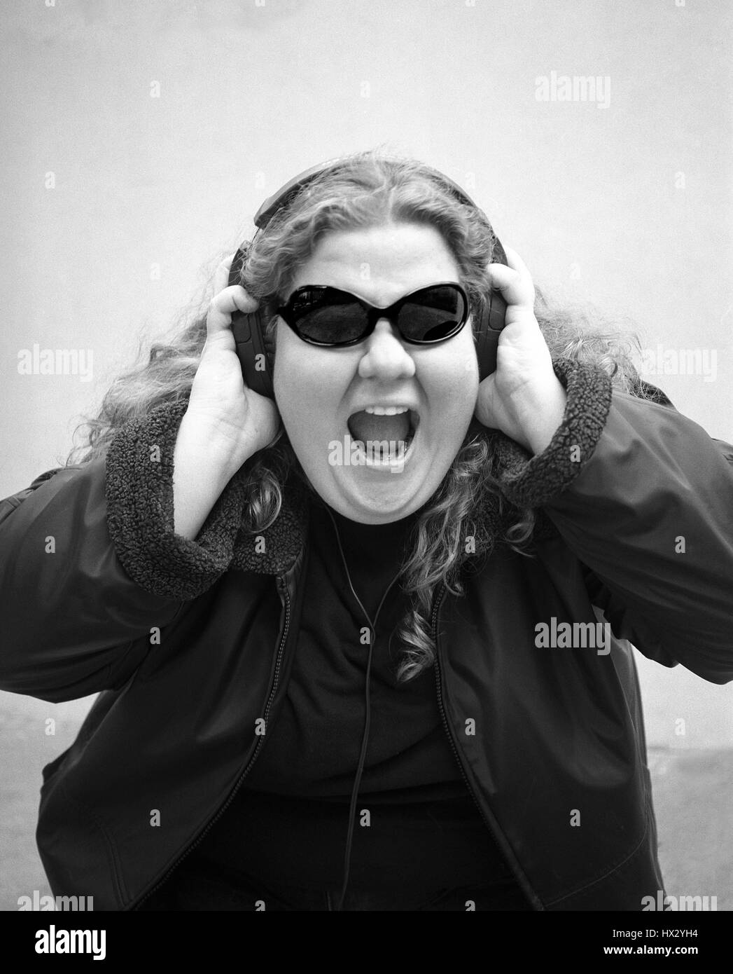 Frau trägt Kopfhörer und Sonnenbrille zu schreien. Stockfoto