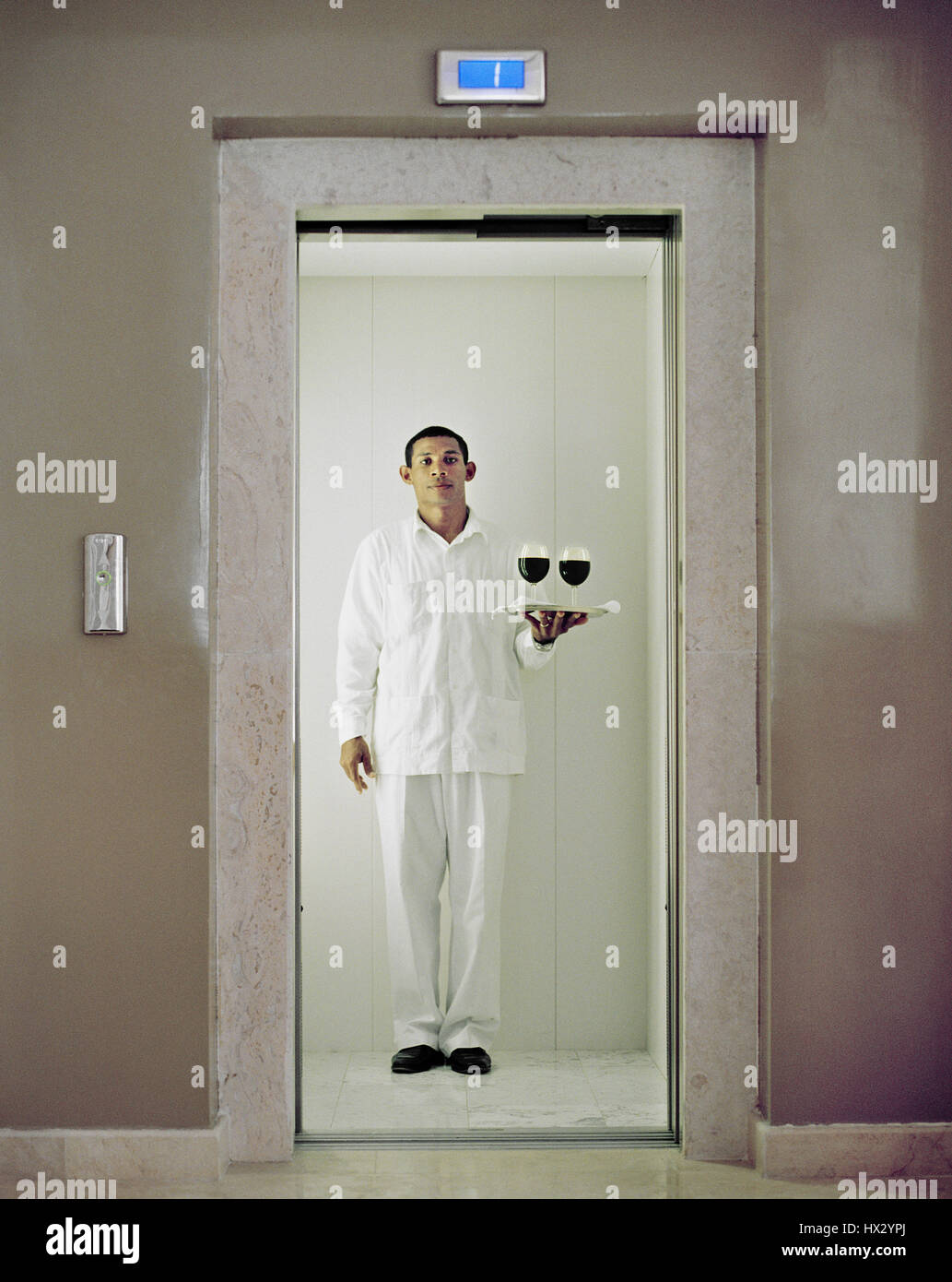 Ein Kellner bringt Wein in die Präsidentensuite im Hotel Casa Colonial, Playa Dorado, Dominikanische Republik. Stockfoto