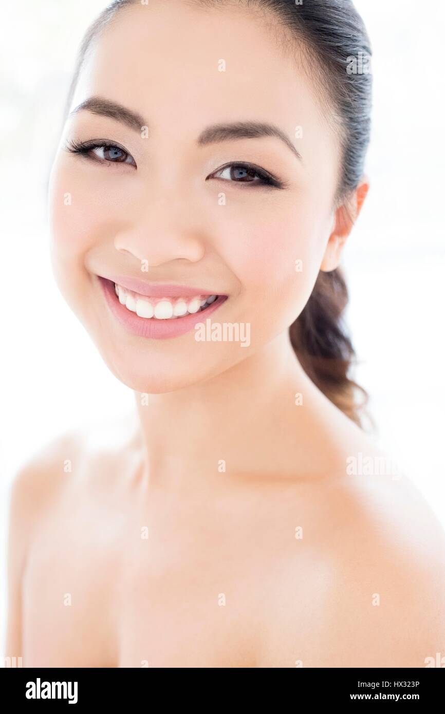 -MODELL VERÖFFENTLICHT. Junge asiatische Frau lächelnd in Richtung Kamera, Porträt. Stockfoto