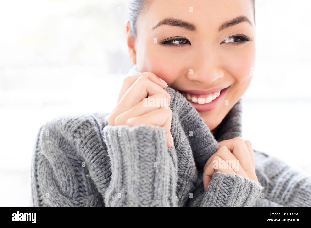 -MODELL VERÖFFENTLICHT. Junge asiatische Frau tragen graue Strickpullover, Portrait. Stockfoto