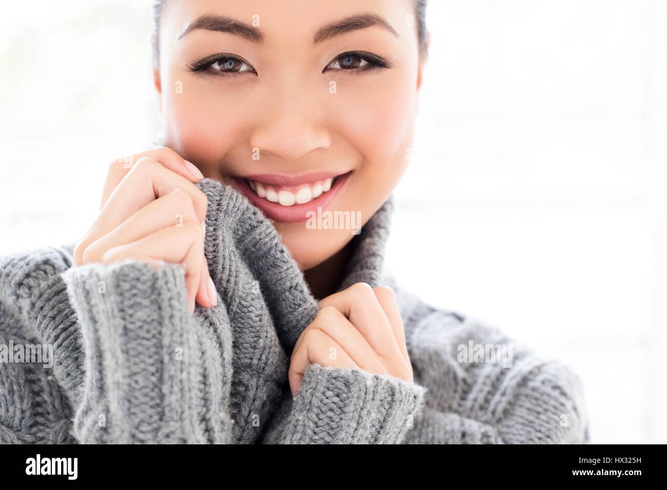 -MODELL VERÖFFENTLICHT. Junge asiatische Frau tragen graue Strickpullover, Portrait. Stockfoto