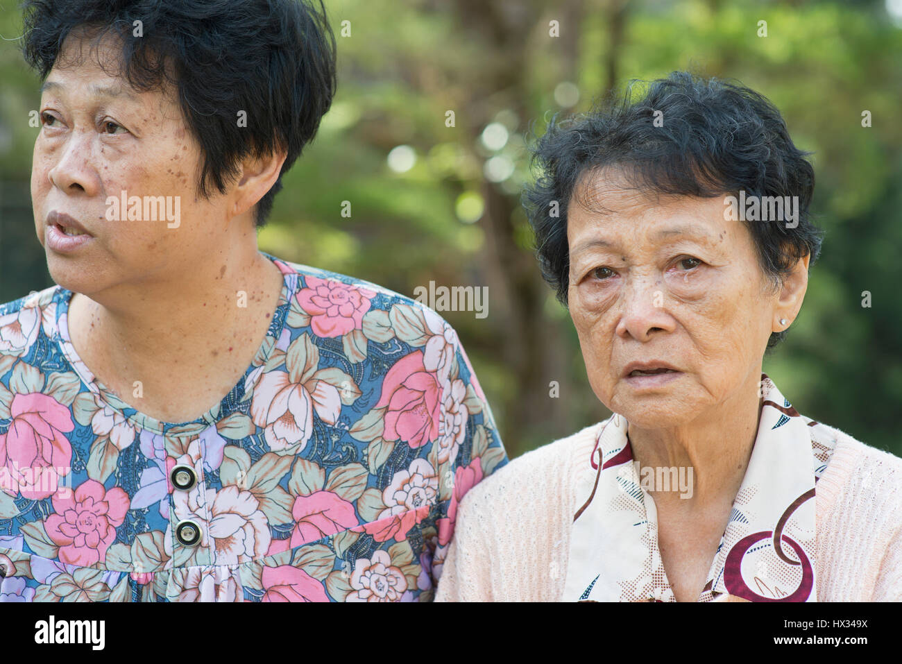 Reportageaufnahme ältere Asiatinnen Klatsch im Outdoor-Park am Morgen. Stockfoto