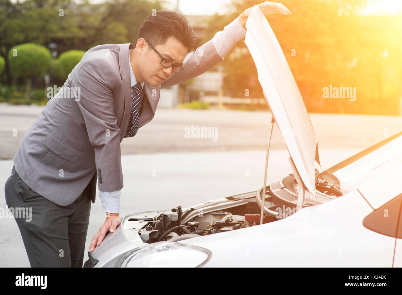 Junge asiatische Geschäftsmann Blick unter die Haube der Aufschlüsselung Auto. Stockfoto