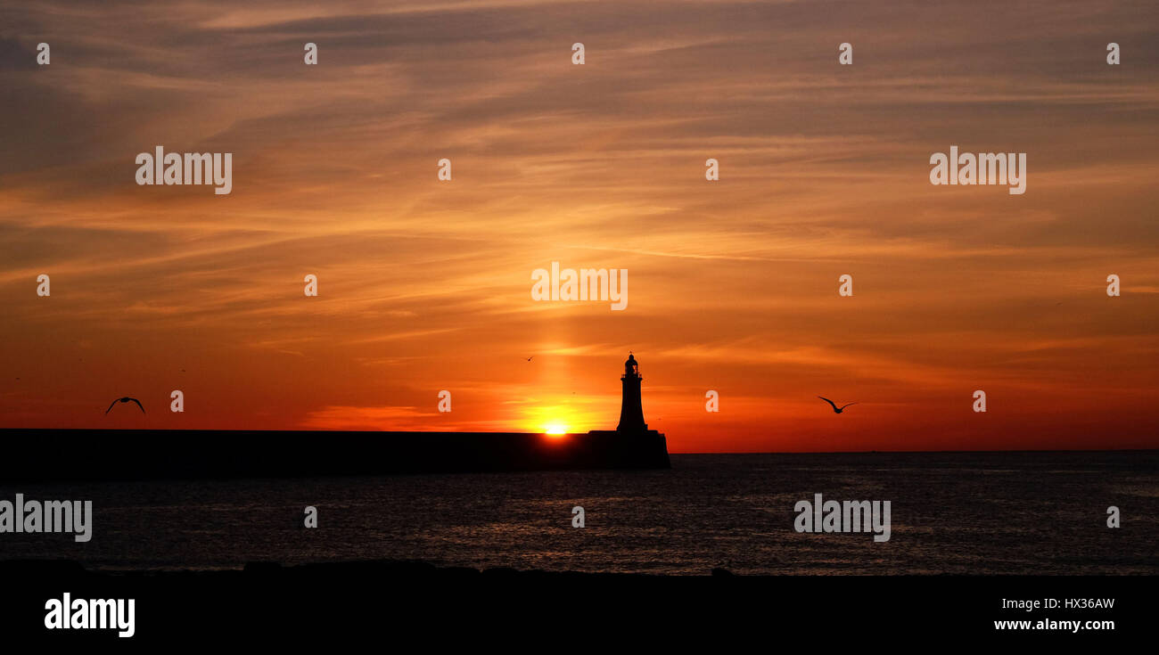 Die Sonne geht über Tynemouth Leuchtturm in Tyne and Wear am letzten Tag bevor die Uhren vorwärts zu gehen. Stockfoto