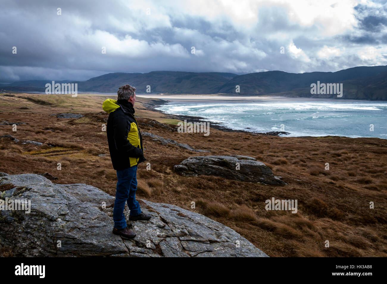 Ein Wanderer blickt als Wellen brechen auf Maghera Strand in der Nähe von Ardara, County Donegal, Irland Teil Irlands Wild Atlantic Way Stockfoto