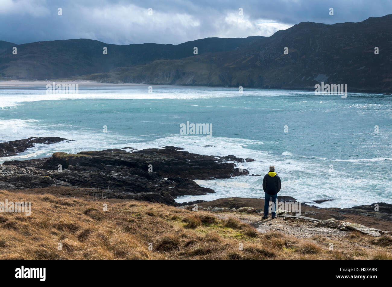 Ein Wanderer blickt als Wellen brechen auf Maghera Strand in der Nähe von Ardara, County Donegal, Irland Teil Irlands Wild Atlantic Way Stockfoto