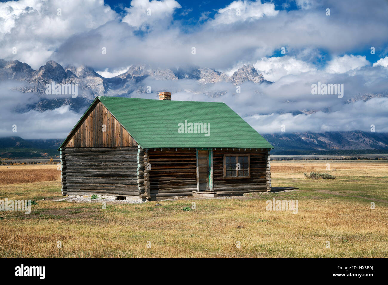 Bunckhouse bei John Moulton Homestead mit Teton Mountains und Clearing-Wolken. Teton-Nationalpark, Wyoming Stockfoto