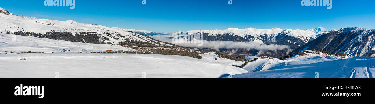 Panoramaaussicht, Snow Valley in alpinen Gebirgszug mit Nadelbäumen bedeckt Bäume und Wolken Stockfoto