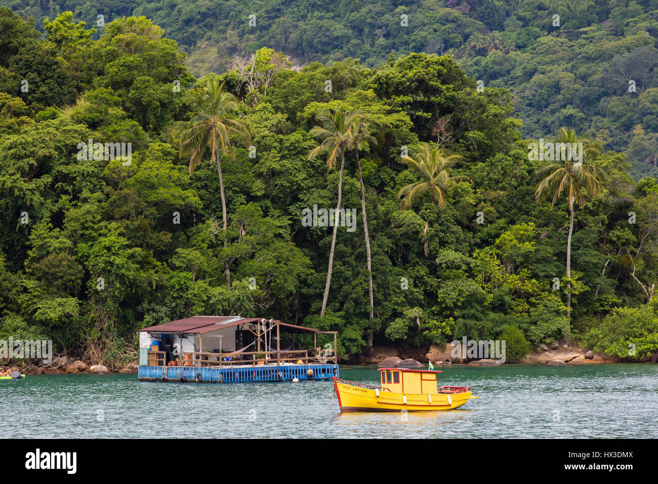 Einem schwimmenden Haus und ein gelbes Boot in der Bucht von Villa Abraão. Ilha Grande, RJ, Brasilien. Stockfoto