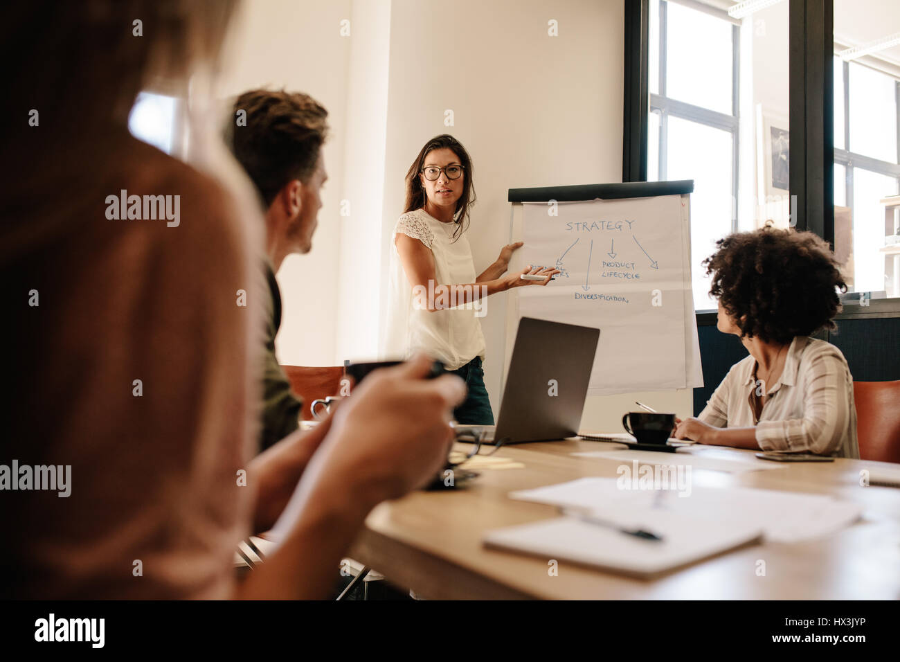 Weibliche Führungskraft neue Unternehmensstrategie, Kollegen im Konferenzraum zu erklären. Business-Team-Meeting im Büro Sitzungsraum. Stockfoto