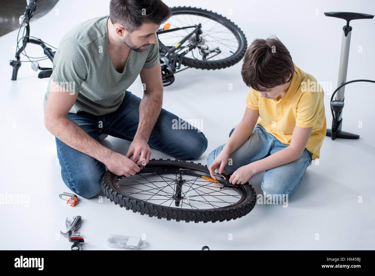 Sohn und Vater Reparatur Fahrradreifen im Studio auf weiß Stockfotografie -  Alamy