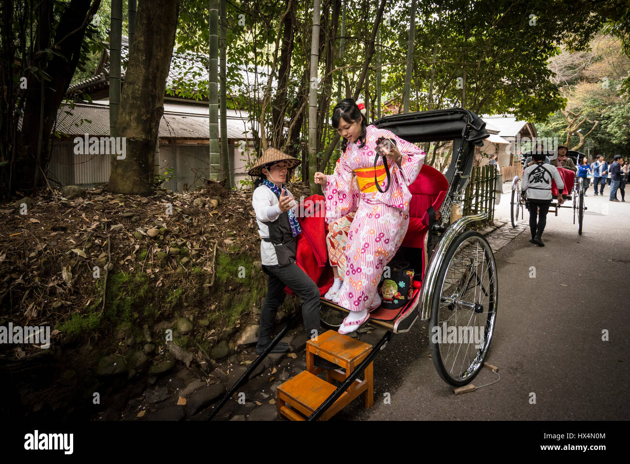 Eine Rikscha, gezogen von einem männlichen in traditionellen Arbeiter Uniform und eine Beifahrerin im Kimono, japanische Tracht, Kyoto, Japan Stockfoto