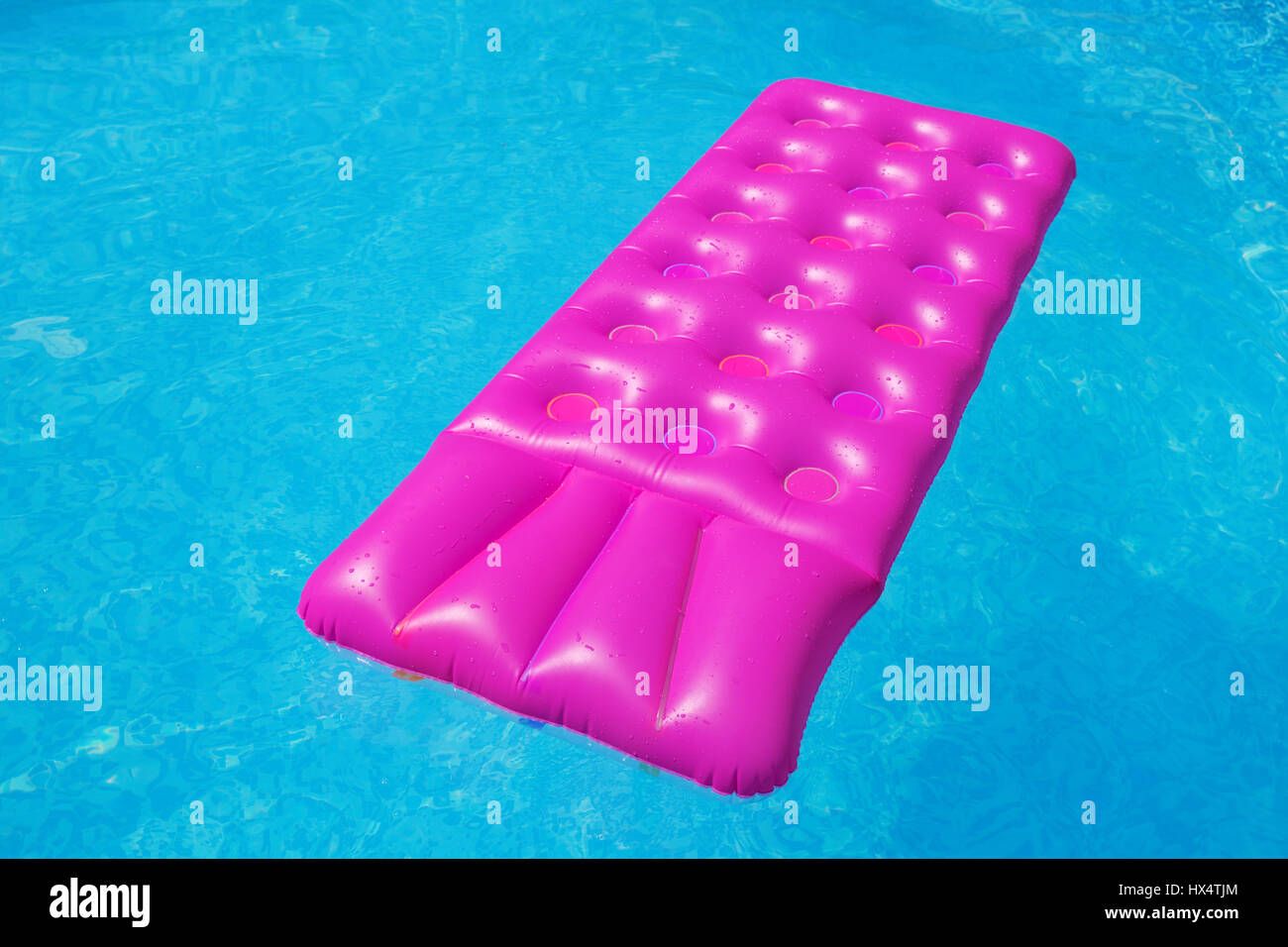 Rosa Luftmatratze auf ein Schwimmbad - Ferienkonzept tropischen Hintergrund Stockfoto