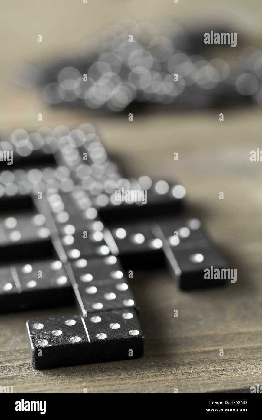 Spiel von Domino mit Domino-Steinen auf hölzernen Hintergrund; selektiven Fokus auf Domino-Stein vor Stockfoto