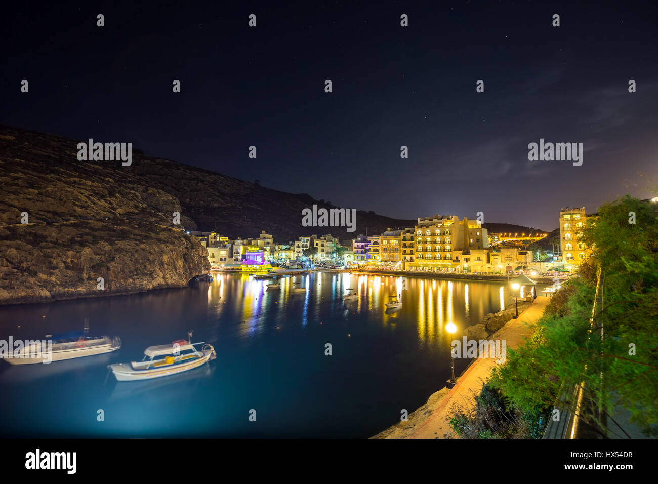 Xlendi, Gozo - schöne Luftaufnahme über die Bucht von Xlendi bei Nacht mit Restaurants, Boote und lebendiges Nachtleben auf der Insel Gozo Stockfoto