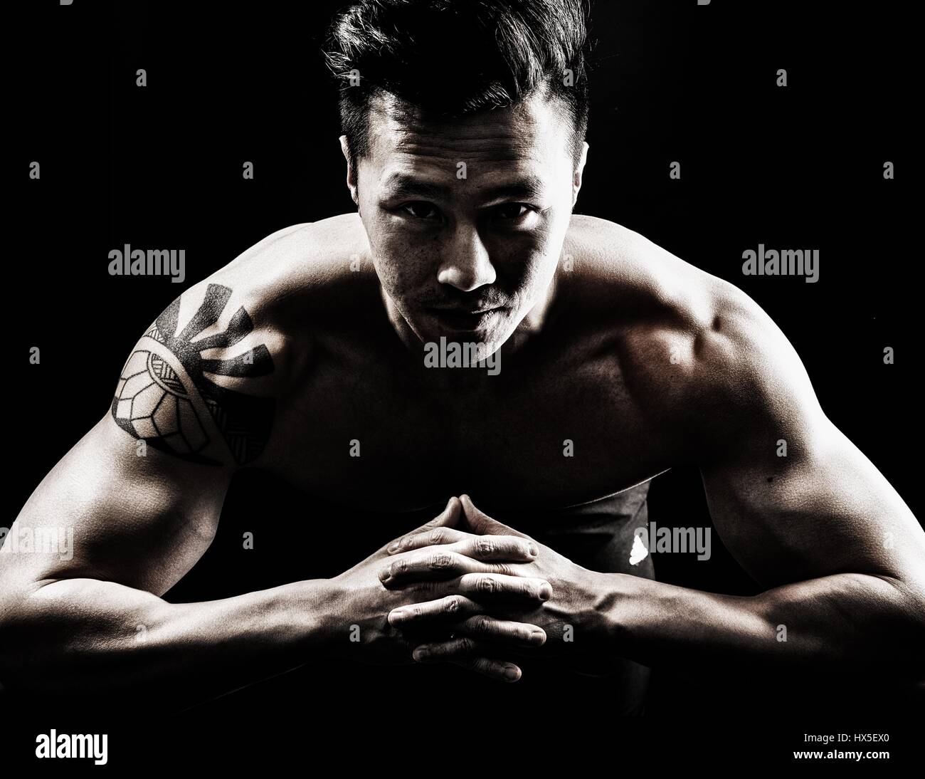 Muskulöser asiatischen Mann vor schwarzen Hintergrund Stockfoto