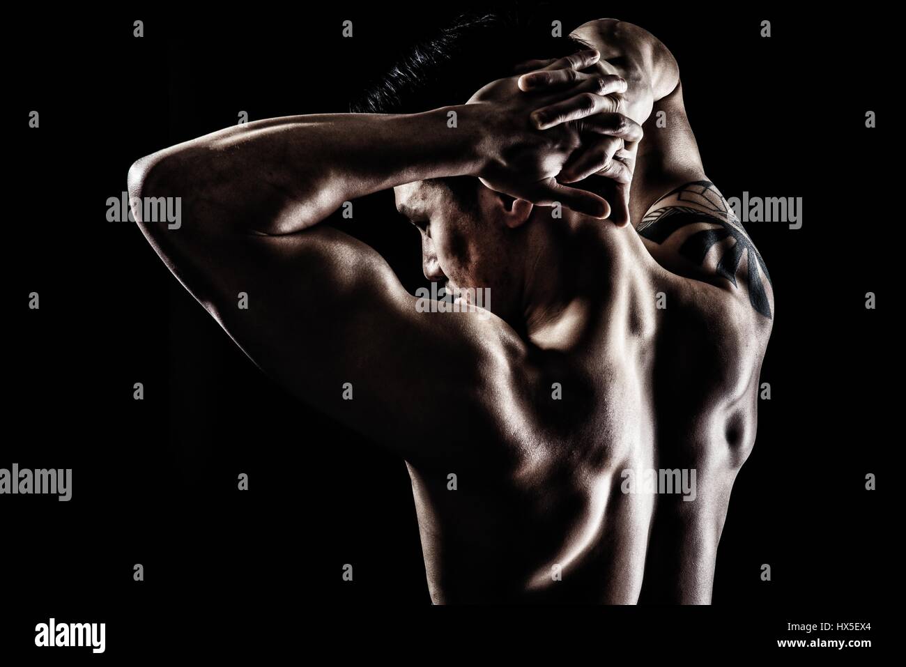 Muskulöser asiatischen Mann vor schwarzen Hintergrund Stockfoto