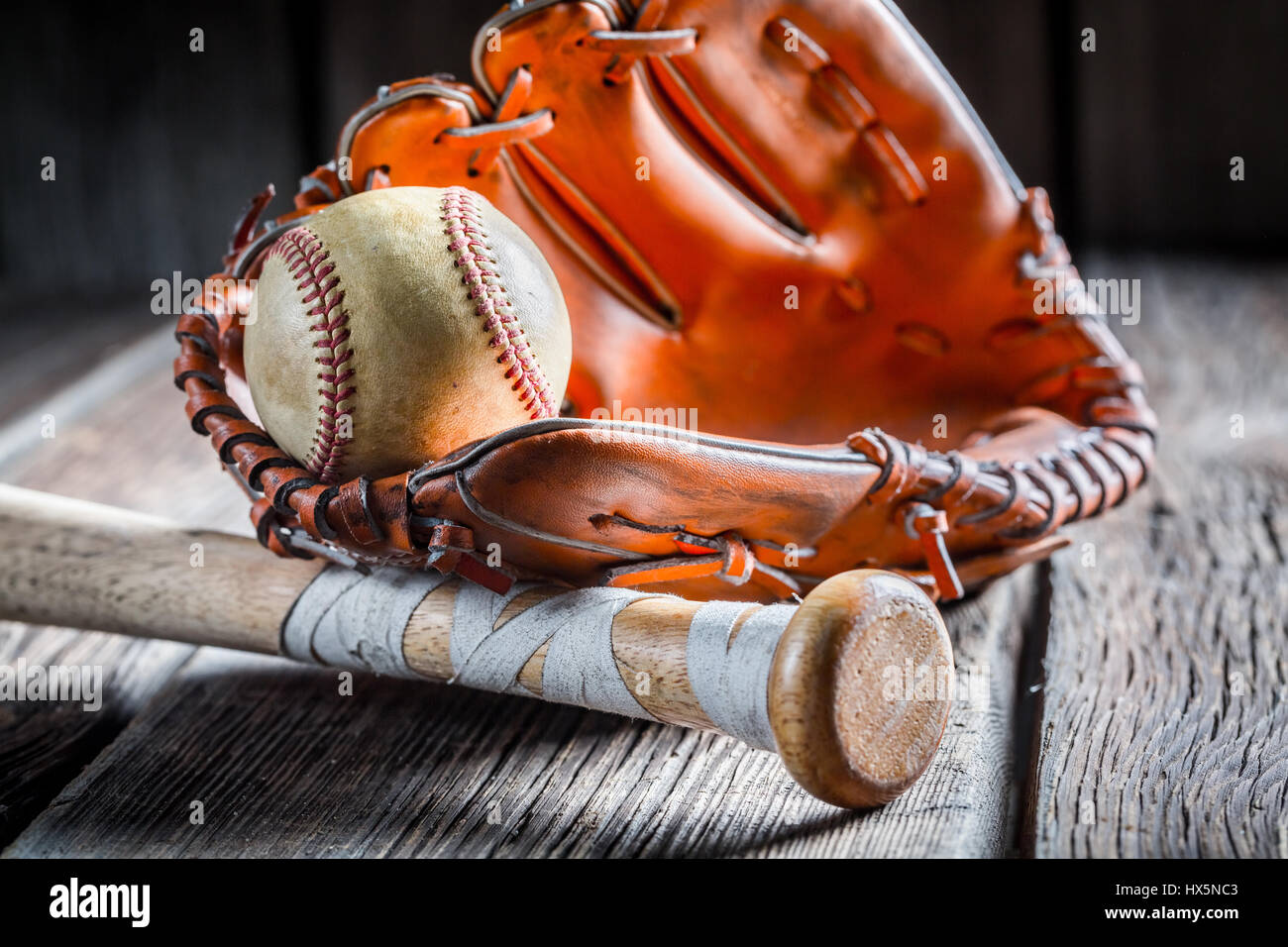 Alten Baseball Ball und goldener Handschuh auf alten Holztisch Stockfoto