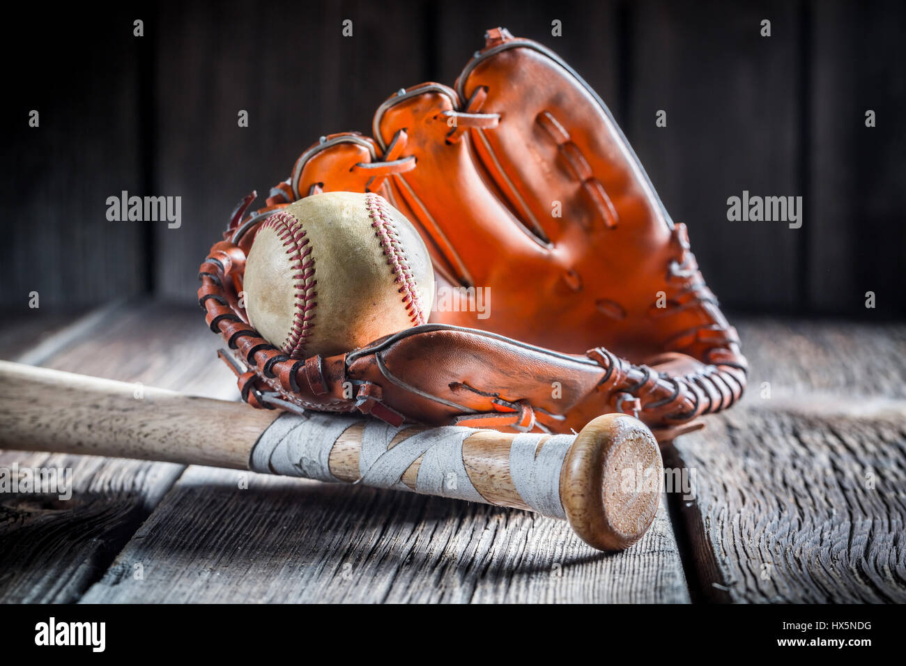 Vintage Baseball Ball und goldener Handschuh auf alten Holztisch Stockfoto