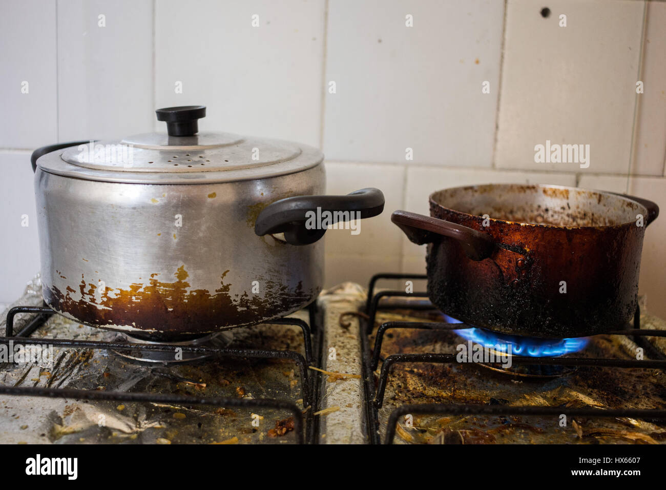 Schmutzige Pfannen auf dreckigen Herd, ungesunde Essgewohnheiten mit Braten darstellt. Stockfoto