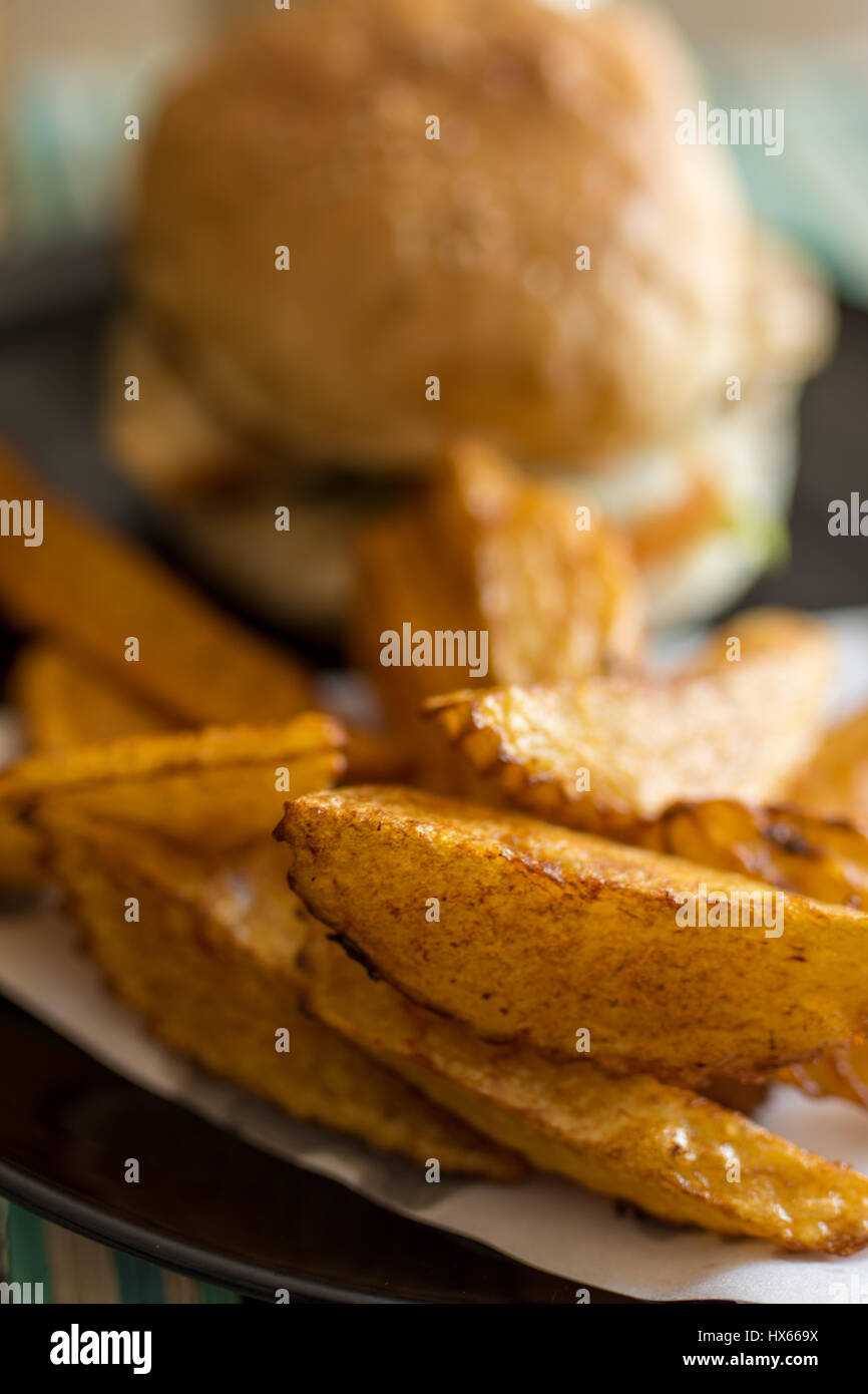 Schärfentiefe-Bereich Foto von Burger und Hand geschnitten Pommes Frites auf einem Teller. Stockfoto