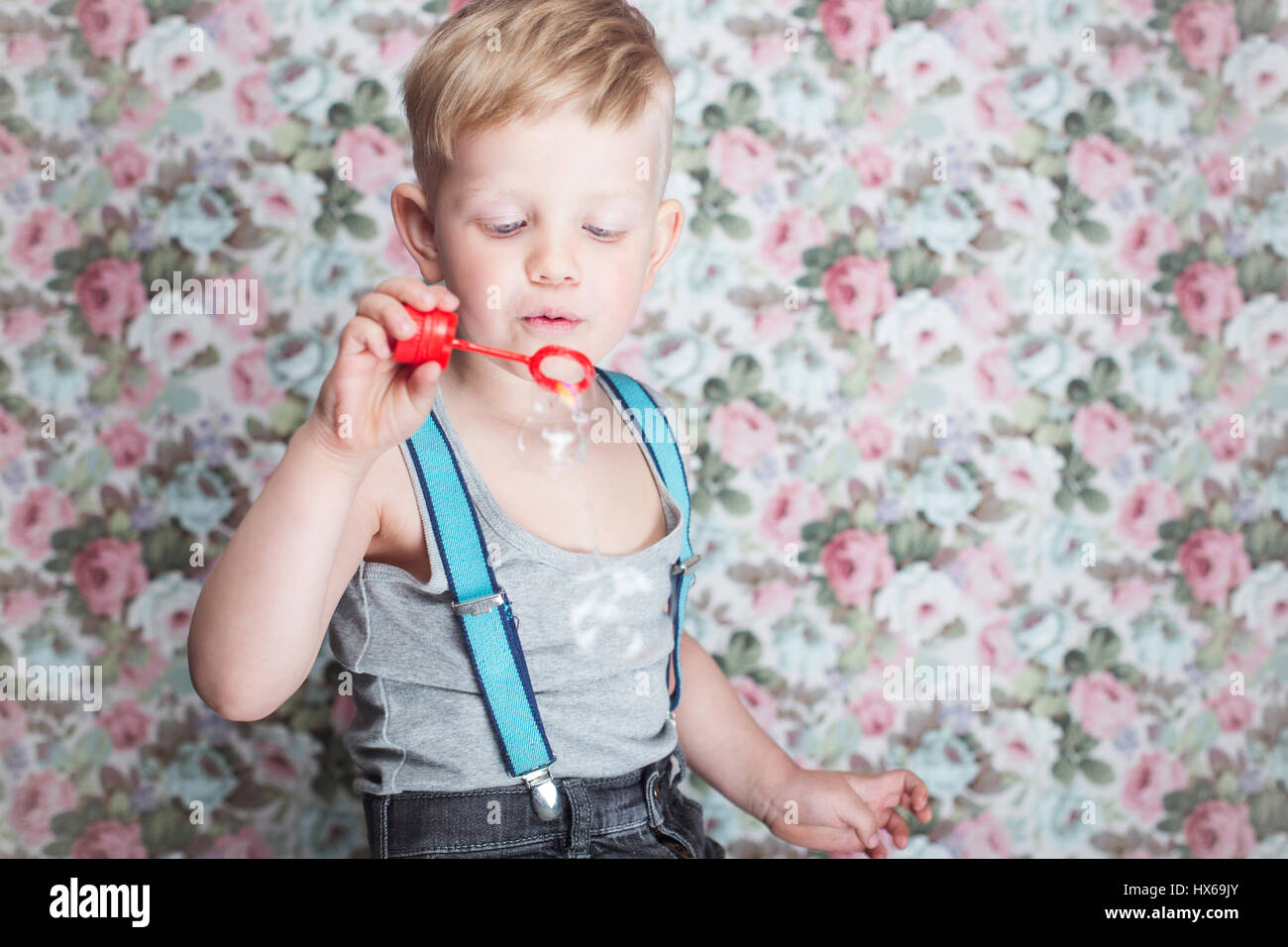 Porträt von lustigen kleinen Jungen Seifenblasen. Hintergrund: blumig, weich, Pastell Stockfoto