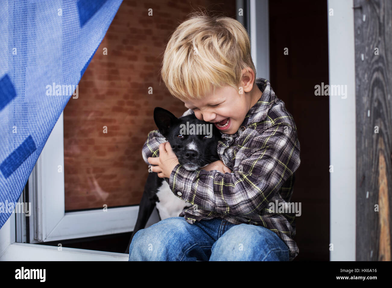 Lächeln, schöne blonde junge und sein Hund. Junge und Basenji. Outdoor portrait Stockfoto