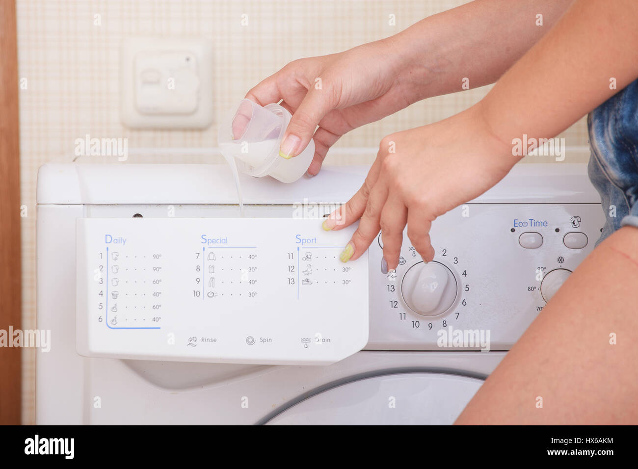 Nahaufnahme eines Mädchens Hand Waschmaschine einstellen. Stockfoto