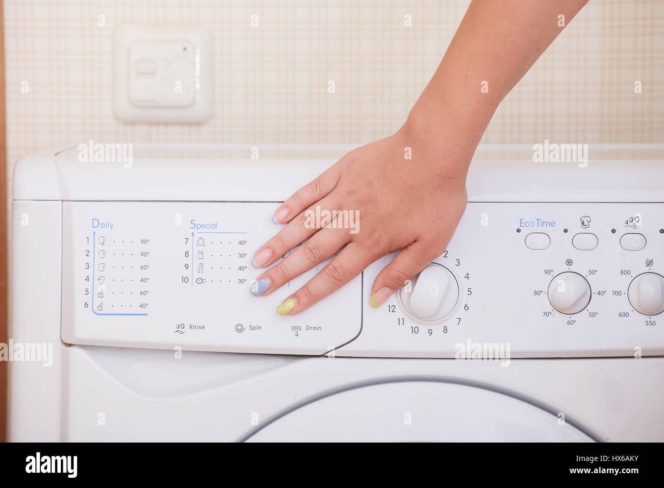 Nahaufnahme eines Mädchens Hand Waschmaschine einstellen. Stockfoto