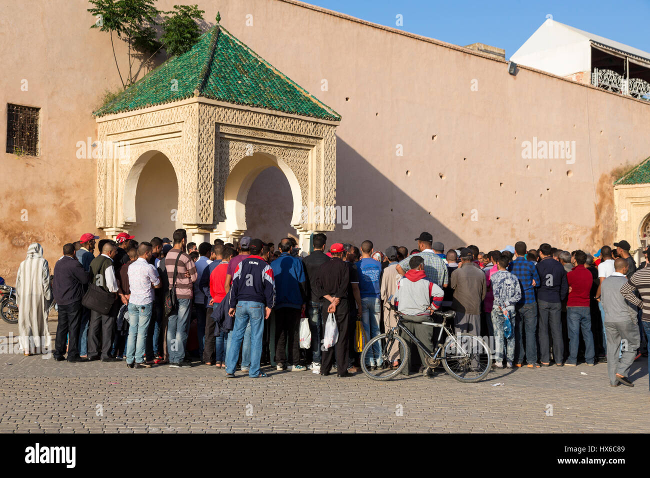 Meknès, Marokko.  Eine Menge von Männern hören ein Geschichtenerzähler in den Ort Hedime.  Die meisten Männer sind in der westlichen, europäischen Kleidung. Stockfoto