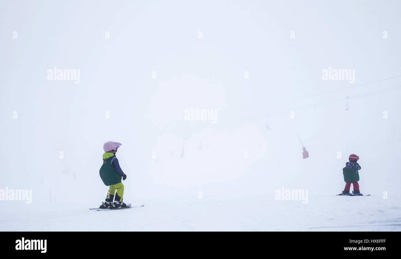 Zwei kleine Kinder, mit einem Skikurs in sehr nebligen Bedingungen in Meribel, Frankreich, in den französischen Alpen Stockfoto