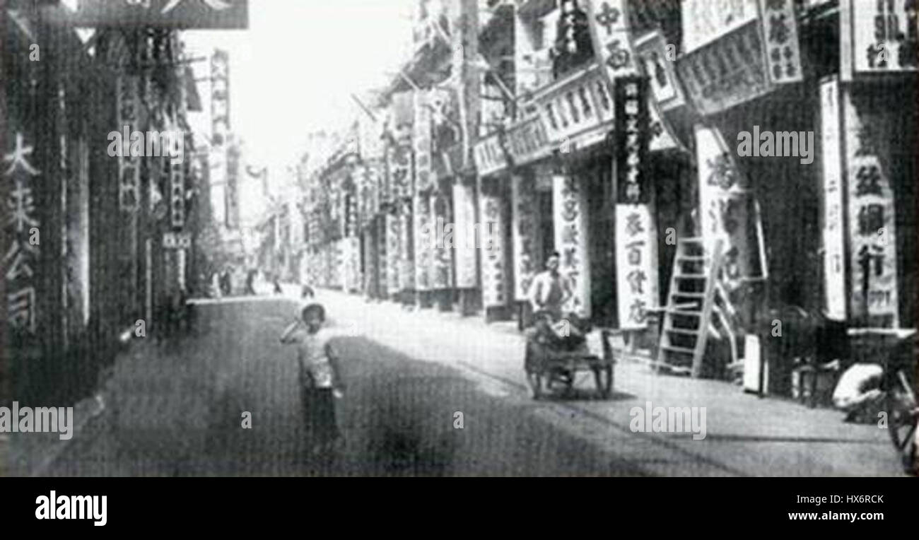 „Shang Hai Street in den frühen 1900er Jahren“ zeigt das geschäftige urbane Leben von Shanghai und erfasst die architektonischen und kulturellen Veränderungen der Stadt während einer Zeit der Modernisierung. Stockfoto