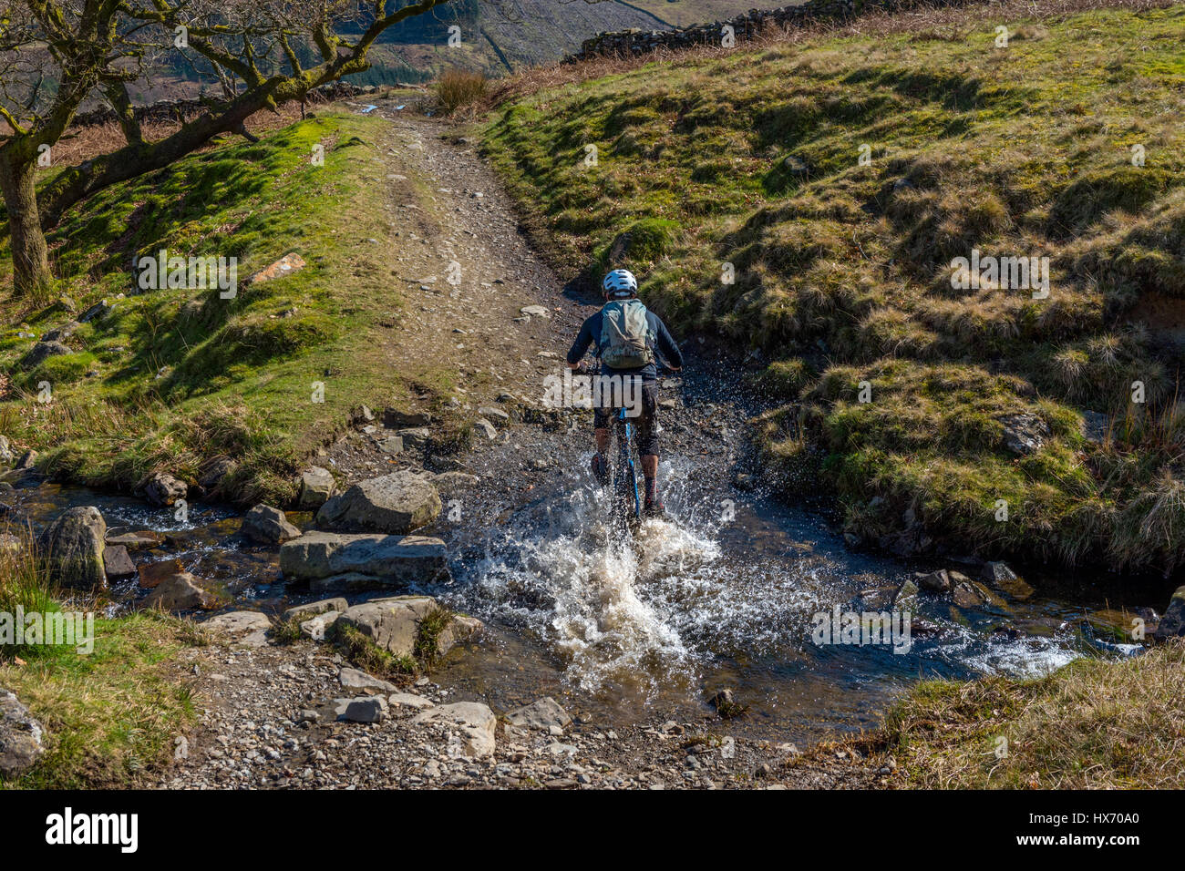 Mountainbiker, die Kreuzung schwarz Beck in Kentmere Cumbria Stockfoto