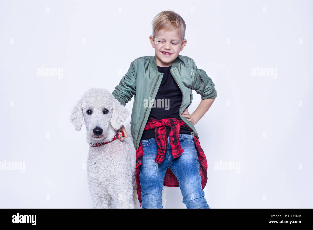 Modische kleine Junge mit Hund. Freundschaft zwischen Mensch und Tier. Studioportrait isoliert auf weißem Hintergrund Stockfoto