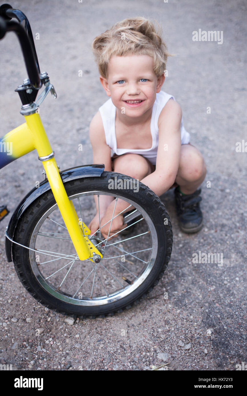 Junge Rad des Fahrrades befestigen. Childhood.Cycling Stockfoto
