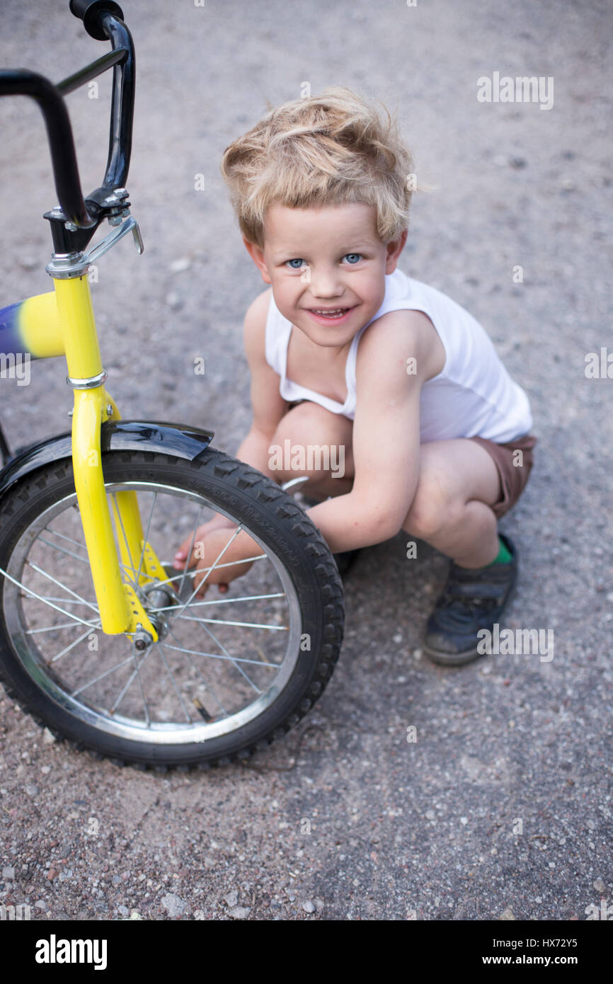 Junge Rad des Fahrrades befestigen. Childhood.Cycling Stockfoto