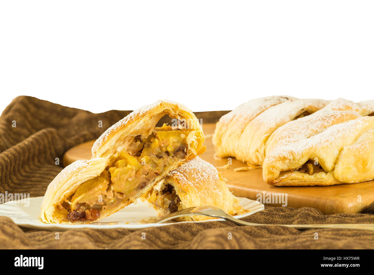 Nahaufnahme von einem Stück hausgemachten Apfelstrudel mit Blätterteig, Zimt und Rosinen, auf einem weißen Hintergrund (Äpfel Pie) Stockfoto