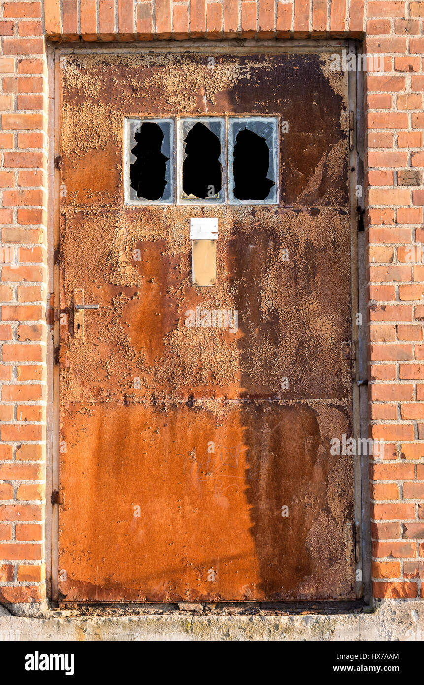 rostige Tür am alten Industriegebäude Stockfoto