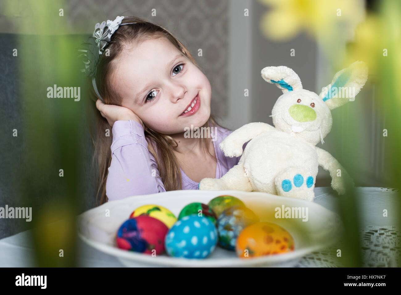 Süßes Kind mit Ostereiern und Plüsch Hase lächelnd. Ostern, Urlaub und Kind Konzept Stockfoto
