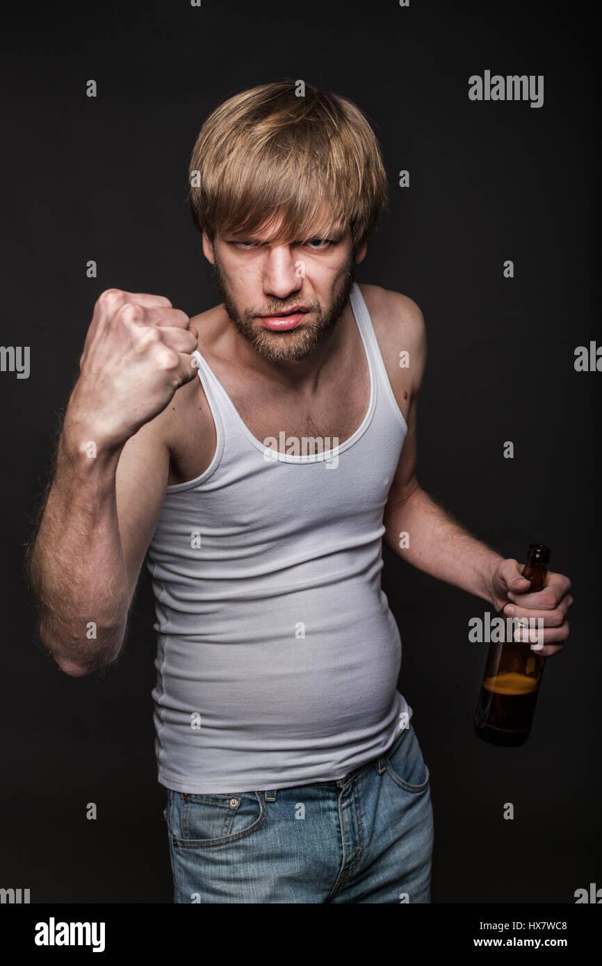 Betrunkener Mann drohen mit Faust. Studio-Porträt über schwarzen Hintergrund Stockfoto