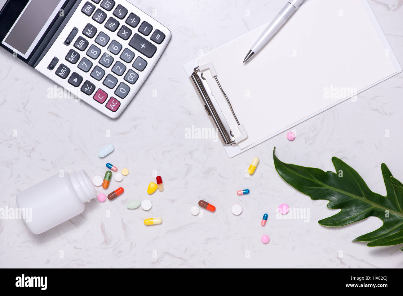 Kosten für das Gesundheitswesen Konzept. Geöffnete Medizinfläschchen und verschüttete, Kapseln auf Tisch. Stockfoto