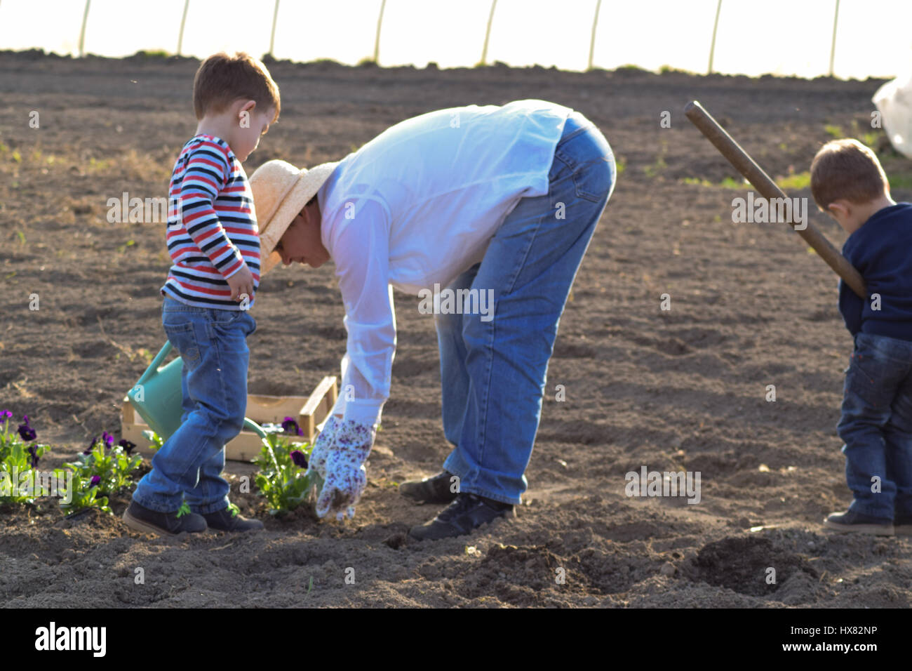 Frauen mit Kindern im Garten arbeiten Stockfoto