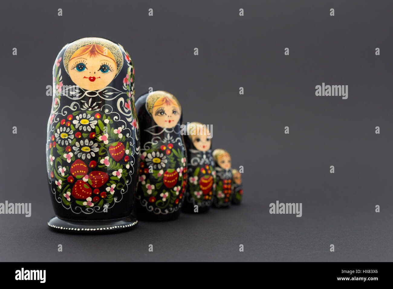 Schöne schwarze russische Verschachtelung Puppen (Matroschka Puppen) mit weißen, grünen und roten Anstrich vor dunklem Hintergrund Stockfoto