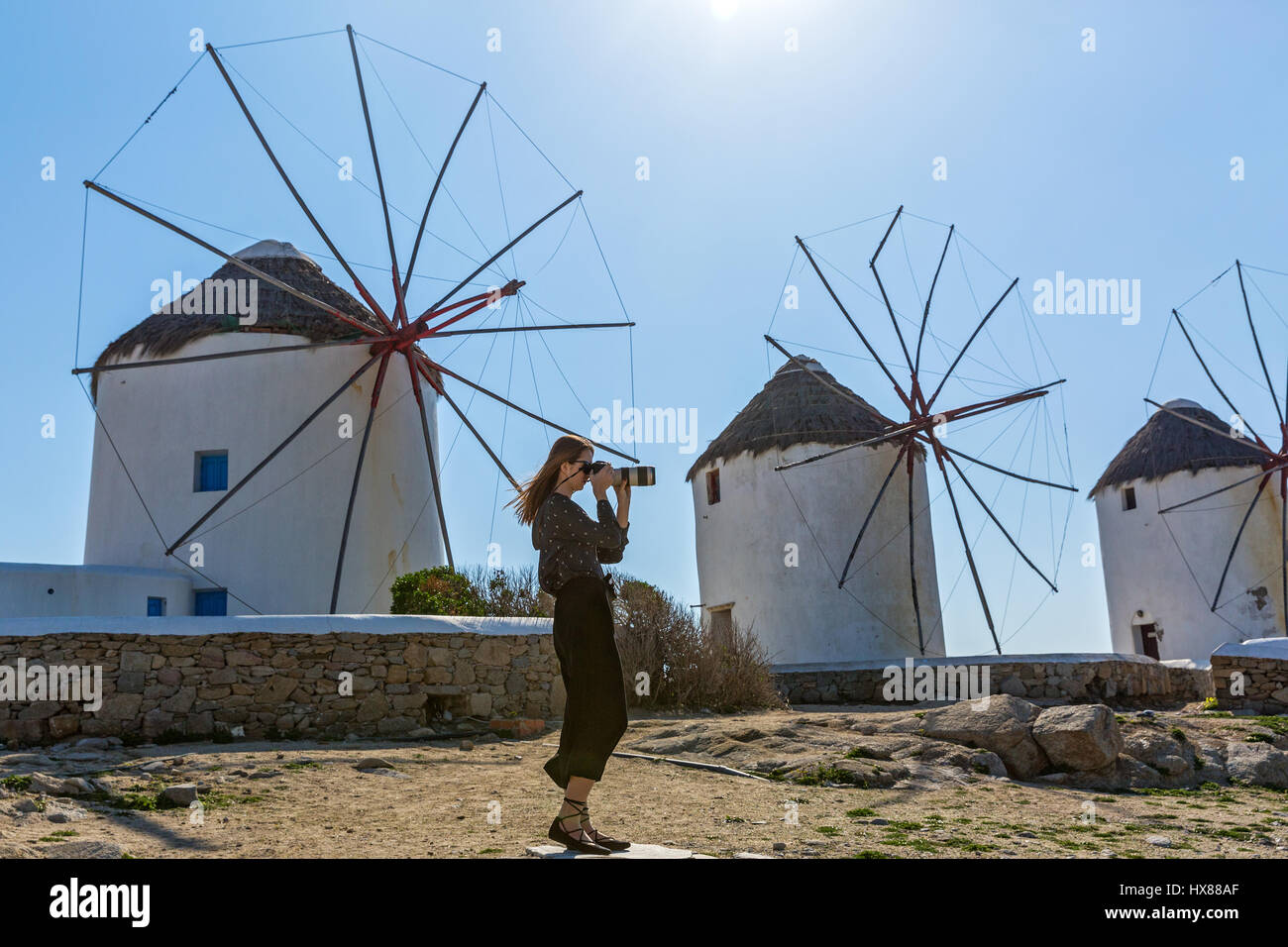 Frau-Fotograf in der Nähe der alten Windmühlen von Mykonos, Griechenland Stockfoto
