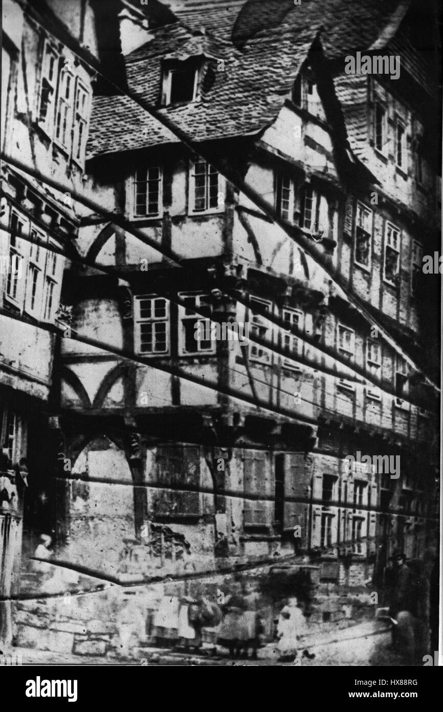 Dieses historische Bild von Marburgs „Haus mit den Knaggen“ aus der Zeit vor 1859 zeigt ein typisches Beispiel mittelalterlicher Architektur in Deutschland. Zu den charakteristischen Merkmalen gehören die Verwendung von Holzhalterungen und das steile Dach, das für die Fachwerkhäuser der Region typisch ist. Stockfoto