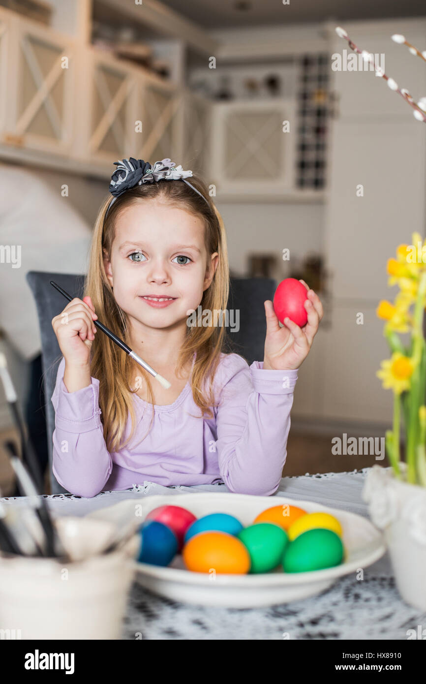 Ein glückliches kleines Mädchen Ostereier färben. Gemütliche Atmosphäre zu Hause. Ostern Stockfoto